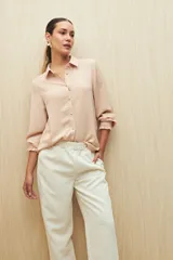 Pantalón de vestir color crema, de corte recto, con bolsillos laterales y cintura elastizada.