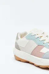 Zapatilla urbana de diseño contemporáneo con capellada que combina paneles de diferentes texturas en color negro, ajuste con cordones y suela robusta de color blanco.