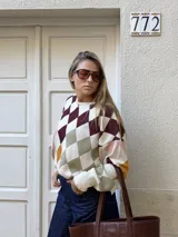 Sweater de punto con diseño de rombos multicolor en tonos bordó, verde, amarillo, rosa y crema. Presenta silueta oversize, cuello redondo y mangas largas abullonadas.