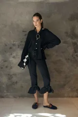 Camisa de corte relajado y caída fluida, con cuello clásico, mangas largas con puños anchos y cierre frontal con botones a contraste.
