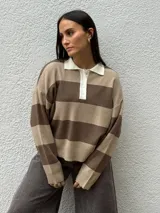 Sweater de tejido bremer con diseño de chomba a rayas horizontales en tonos marrones y beige, cuello polo en color crema con cierre frontal de botones y mangas largas.