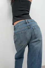 Jeans de tiro bajo con corte wide leg y largo cropped. Presenta diseño de cinco bolsillos, trabillas para cinturón y cierre frontal con cremallera y botón metálico.