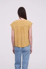 Blusa sin mangas de corte holgado, confeccionada en tela de viscosa con estampado de rayas verticales en tonos mostaza y blanco. Presenta cuello en V profundo y detalles bordados en los hombros.