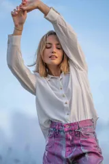 Camisa color crudo de poliéster con botones dorados en forma de estrella.