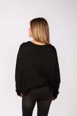 Sweater negro de corte holgado con cuello redondo y mangas largas. Presenta detalles de botones metálicos dorados a lo largo de los hombros y las mangas.
