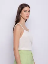 Top sin mangas de tela texturada color verde lima, con tirantes finos y escote cuadrado con detalle de terminación festoneada.