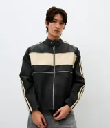 Campera estilo racing confeccionada en poliuretano, con diseño bicolor en negro y beige. Presenta cuello alto con botón a presión, cierre frontal metálico, panel frontal contrastante y franjas laterales deportivas.
