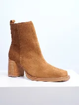 Bota de cuero color marrón con caña baja, punta cuadrada y taco geométrico de madera.