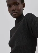 Jersey de punto gris oscuro con cuello alto y mangas largas.