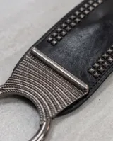 Cinto ancho tipo faja, color negro, confeccionado en material elástico con múltiples filas de tachas metálicas en los laterales.