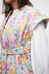Chaleco con estampado floral multicolor, cuello mao, sin mangas y lazo de ajuste en la cintura.