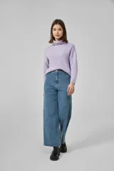 Pantalón de jean negro, de corte ancho y tiro alto, con ruedo deshilachado.