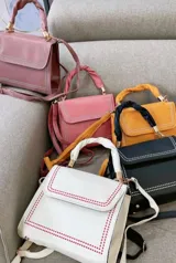 Cartera bandolera con asa superior trenzada y correa ajustable. Disponible en blanco con detalles en rojo, negro con detalles en blanco, rosa viejo con detalles en blanco, rosa chicle con detalles en blanco y amarillo con detalles en blanco.
