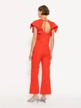 Pantalon de corte flare en color rojo, con tiro medio, cierre frontal con gancho y boton interno, y costuras verticales decorativas en el frente.