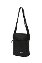 Morral negro con dos bolsillos frontales, cierre de cremallera con tiradores rojos y correa ajustable. Incluye una etiqueta con el texto "NOT JUST A BAG".