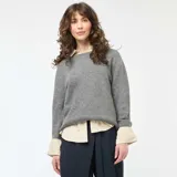 Sweater de punto grueso en color gris, con cuello redondo, mangas largas y corte holgado.