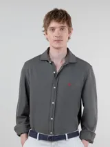 Camisa gris de punto liso para hombre, confeccionada en 100% algodón. Corte regular fit, cuello italiano, manga larga con puño simple y logo bordado en rojo en el pecho.