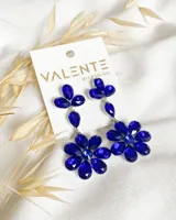 Aros colgantes con forma de flor, con apliques de piedras facetadas color azul.