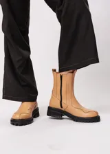 Bota de cuero color camel, estilo Chelsea, con elásticos laterales negros y suela track negra.