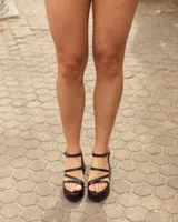 Sandalias de cuero negro con plataforma y taco chino, tiras finas en el empeine y tira ajustable con hebilla en el tobillo.