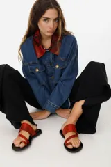 Sandalias de cuero color marrón con tira ancha sobre el empeine y tira entre los dedos.