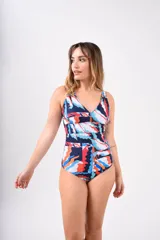 Malla enteriza de lycra con protección UV 50 y forro interior. Presenta un estampado tipo ikat en tonos verde oscuro y beige, con escote en V profundo y fruncido cruzado en la zona del busto.