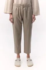 Pantalón estilo chino color beige con elástico en la cintura y cierre metálico en la pierna. Cuenta con bolsillos laterales con cierre invisible.