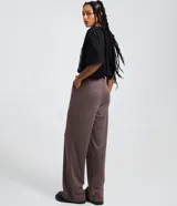 Pantalón wide leg de sastrería color gris con estampado de raya de tiza, tiro alto con cintura fija, pliegues delanteros y cierre frontal con botón y cremallera.