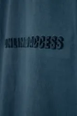 Remera de manga corta con corte oversize, color azul petróleo, con estampa frontal en relieve con la frase Unlimited Access.