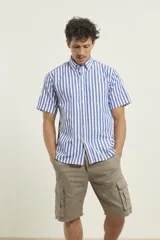 Camisa de manga corta con estampado de rayas verticales en azul y blanco, cuello abotonado y bolsillo frontal en el pecho.