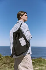 Mochila tipo tote de color negro, con doble asa superior y correas ajustables para llevar en la espalda. Presenta un parche rectangular blanco en el centro con el logo de la marca Jack & Jones.
