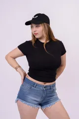 Short de denim azul con tiro medio, bolsillos clásicos y ruedo desflecado con diseño asimétrico en los laterales.