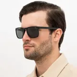 Lentes de sol INVU con montura cuadrada negra y lentes grises polarizadas.