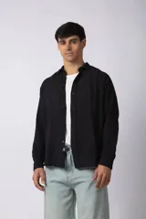 Camisa de manga larga confeccionada en lino, de calce suelto y textura suave. Presenta cuello clásico, cierre frontal con botones y diseño versátil.