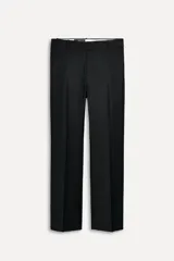 Pantalón de vestir negro de lana con corte recto, tiro bajo, trabillas para cinturón, bolsillos laterales y traseros de doble vivo. Cierre frontal con cremallera, botón interior y ganchos metálicos.