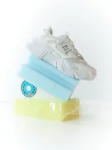 Zapatillas deportivas blancas con suela chunky y detalles de malla.