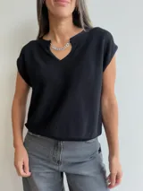 Tejido de punto de manga corta con escote en V, que incluye una cadena decorativa desmontable con cristales. Presenta una textura acanalada fina y un corte holgado.