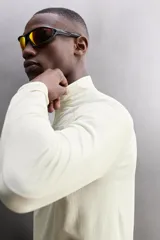 Camiseta de manga larga negra, confeccionada en tejido técnico ligero y elástico. Tiene cuello alto con cremallera, corte slim fit, bolsillo frontal con cremallera y puños con cinta a contraste.