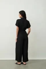 Mono largo negro de corte palazzo con camisa de mangas cortas con botones y lazo en la cintura.