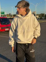 Hoodie de color blanco off-white con diseño de capucha, bolsillo frontal tipo canguro y bordado en relieve con el texto ITTAI STARS y un logo caligráfico.