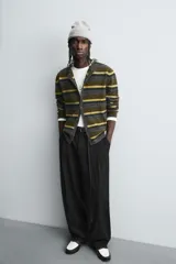 Pantalón de corte balloon fit en color gris, confeccionado en tejido con viscosa. Presenta pliegues frontales, cintura con cinturón integrado a contraste, bolsillos laterales y bolsillos traseros de vivo.