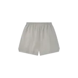Short de felpa color gris claro, de corte holgado, con cintura elástica y cordón de ajuste largo. Cuenta con un pequeño parche rectangular en la parte superior y la inscripción "USA ESSENTIALS" estampada en azul marino en la pierna izquierda.