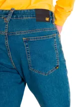 Pantalón de jean corte slim, color azul oscuro, con costuras en contraste y diseño clásico de cinco bolsillos.