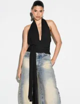 Top halter negro de escote profundo en V, con espalda descubierta, detalle fruncido en la cintura y lazo largo delantero ajustable.