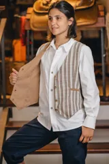 Chaleco reversible de lino, color naranja en el exterior y rayas finas en el interior, con cuello en V y cierre frontal de botones.