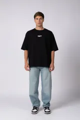 Remera oversize negra de manga corta, con cuello redondo y pequeño estampado frontal con las letras "CNPT".