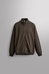 Sudadera de manga larga con cuello subido y cierre frontal de cremallera, confeccionada en tejido ligero con mezcla de algodón, con bolsillos laterales ocultos y acabados en rib.