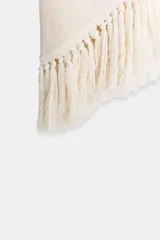 Top halter color crudo, de escote en V y diseño confeccionado en hilatura con mezcla de viscosa. Presenta bajo asimétrico con flecos al tono y cierre en la espalda.