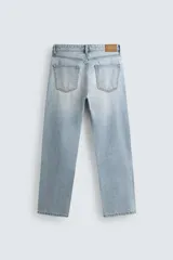 Jeans regular fit de denim de algodón en color gris con efecto lavado, tiro medio, diseño de cinco bolsillos y cierre frontal con botones.