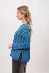 Sweater tejido de punto con franjas verticales azules y verdes, de corte holgado y mangas largas.